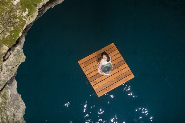 Aerial view of woman sitting on wooden raft