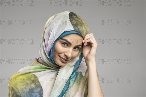 Studio portrait of beautiful woman wearing headscarf