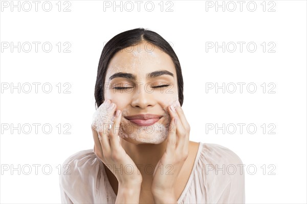 Young woman applying face cleaner