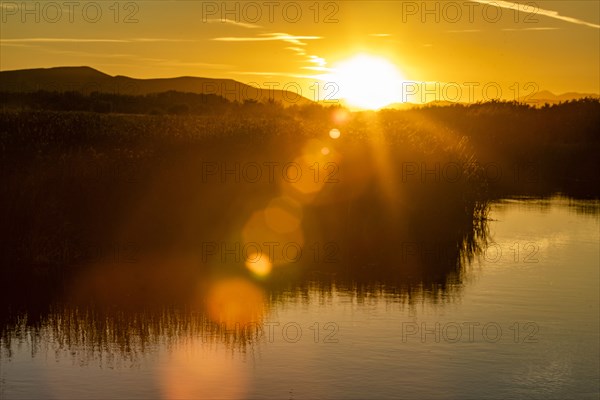 Setting sun reflecting in lake