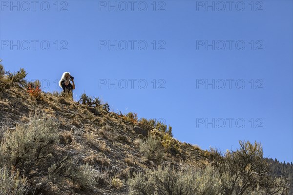 Woman using binoculars in nature