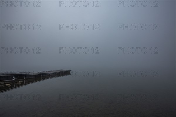 Wooden jetty at edge of mountain lake