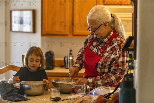 Grandmother and granddaughter bake cookies together