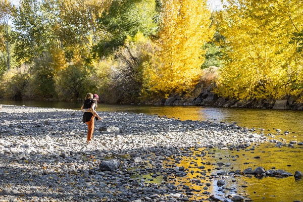 Mother giving daughter piggyback ride at Big Wood River