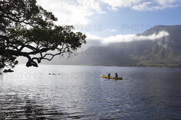 Boy and teenage girl kayaking in lagoon