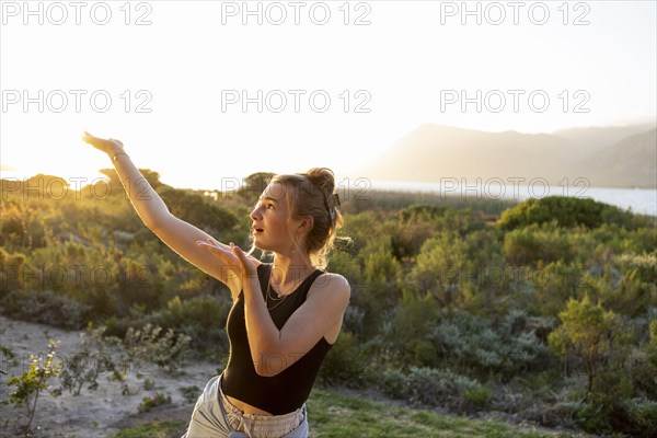 Teenage girl dancing at sunset