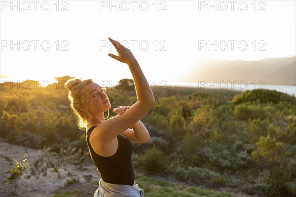 Teenage girl dancing at sunset