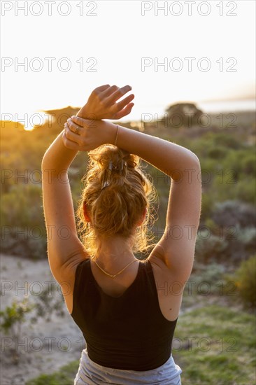 Teenage girl dancing at sunset