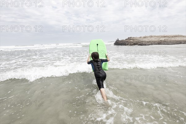Boy bodyboarding on Voelklip beach