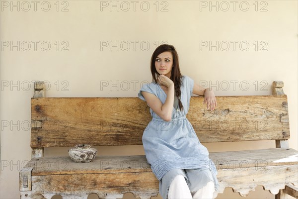 Young woman sitting on antique bench