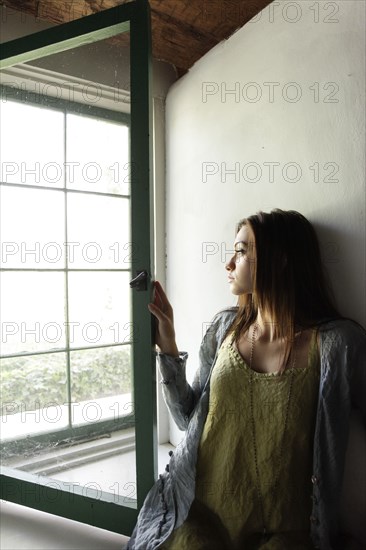 Young woman looking out window