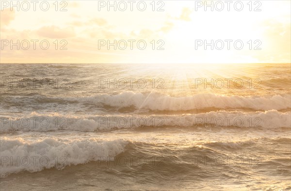 Setting sun shining above ocean