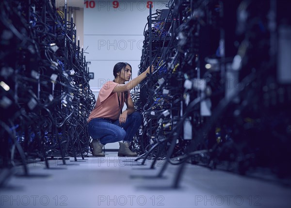 Female technician working in server room