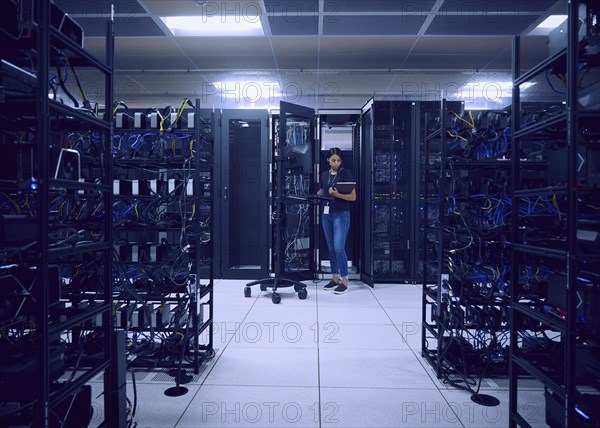 Female technician working in server room