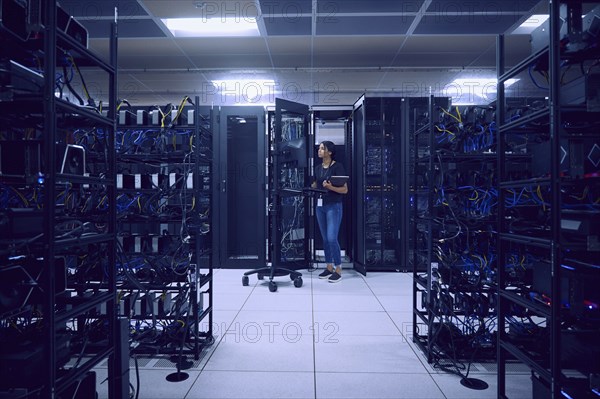 Female technician working in server room