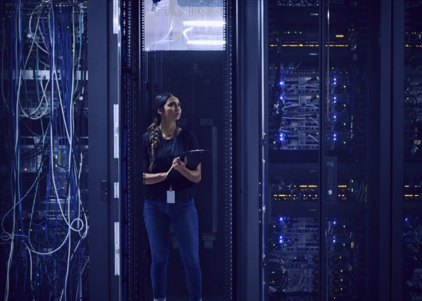 Female technician working in server room