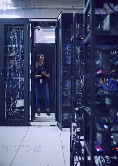 Female technician working in server room