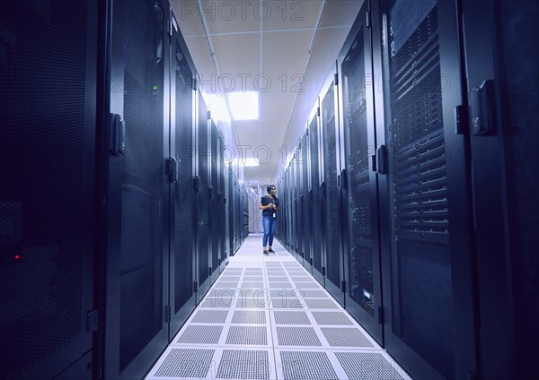 Female technician working in server room