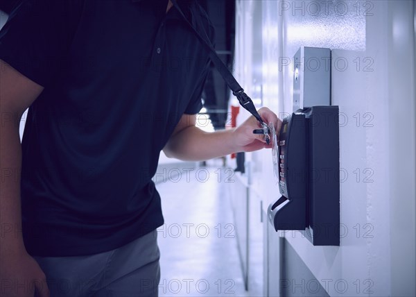 Midsection of man using security card to enter room in data center