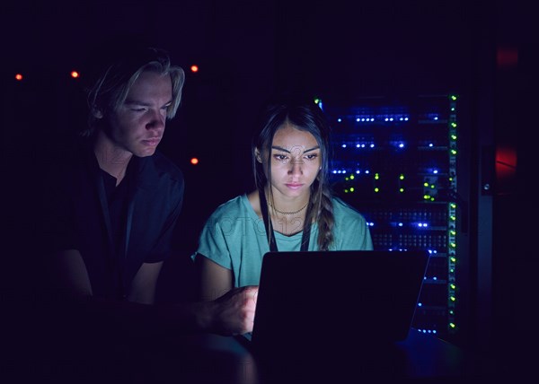 Technicians using laptop in server room