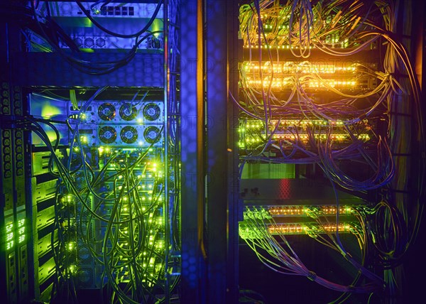 Illuminated servers and computer cables in server room