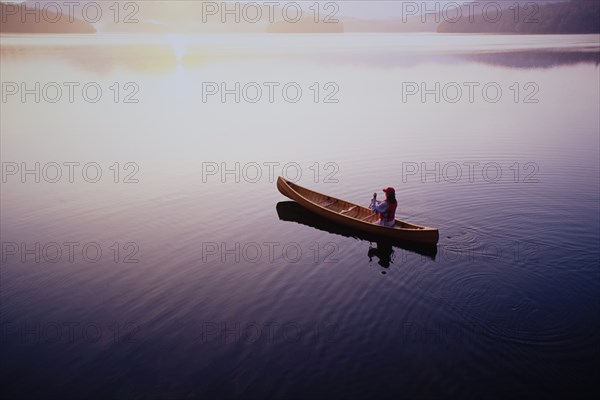 High angle view of woman paddling canoe on Lake Placid at sunrise