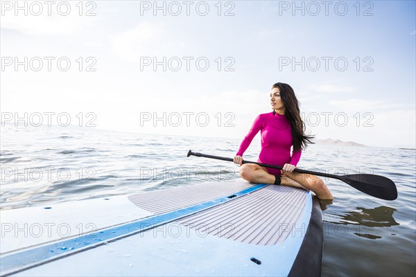Woman sitting on paddleboard