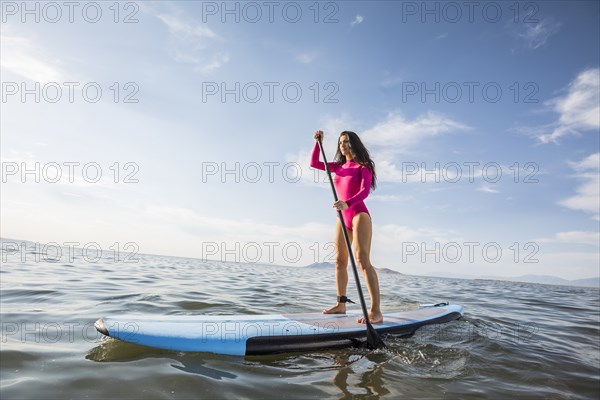 Woman standing on paddleboard in lake