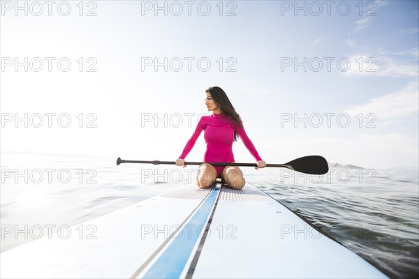 Woman kneeling on paddleboard