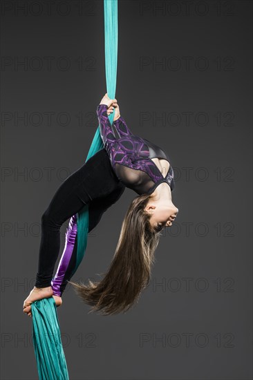 Teenage girl (14-15) during aerial silk practice