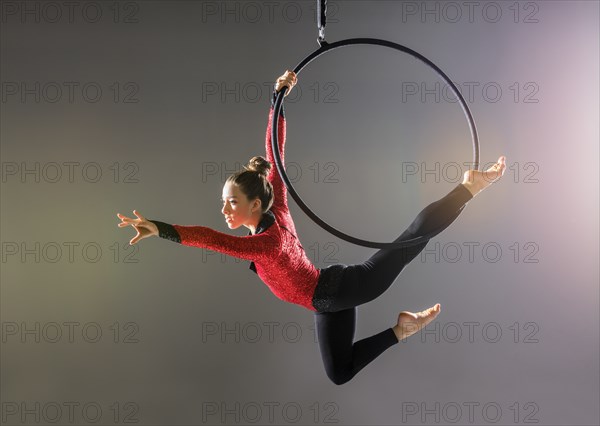 Teenage aerialist (14-15) practicing on gymnastics hoop