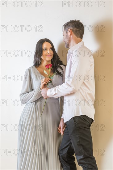 Man looking at woman holding red rose