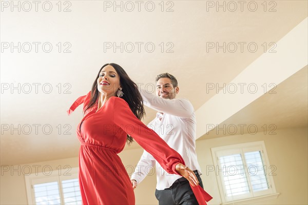 Cheerful couple dancing in apartment