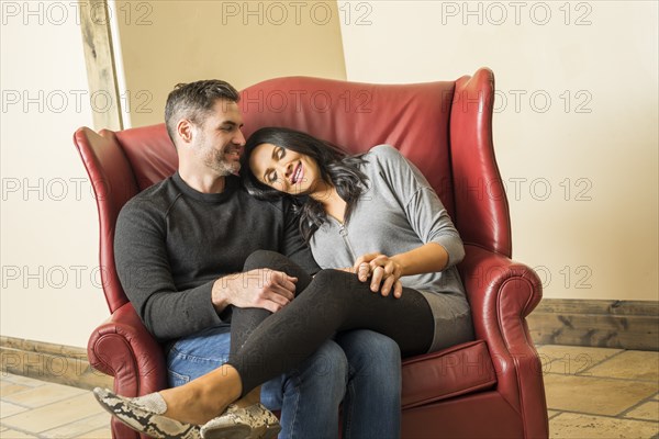 Cheerful couple relaxing on armchair together