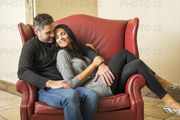 Couple relaxing in armchair together