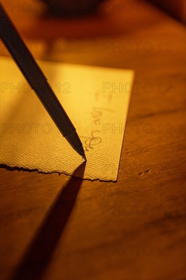 Close-up of pen writing on linen notecard