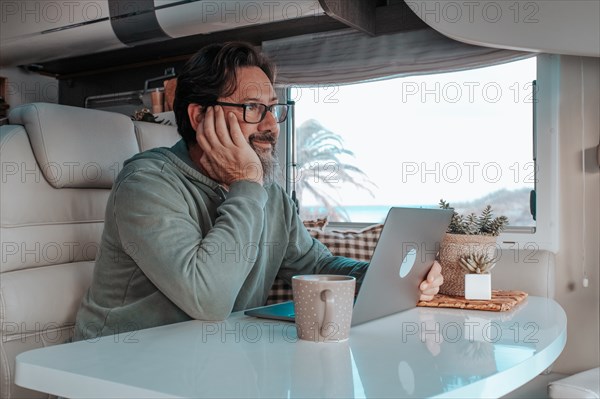 Man sitting in mobile home and working on laptop