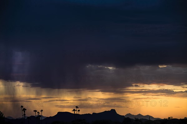 Dramatic storm clouds above landscape at sunset