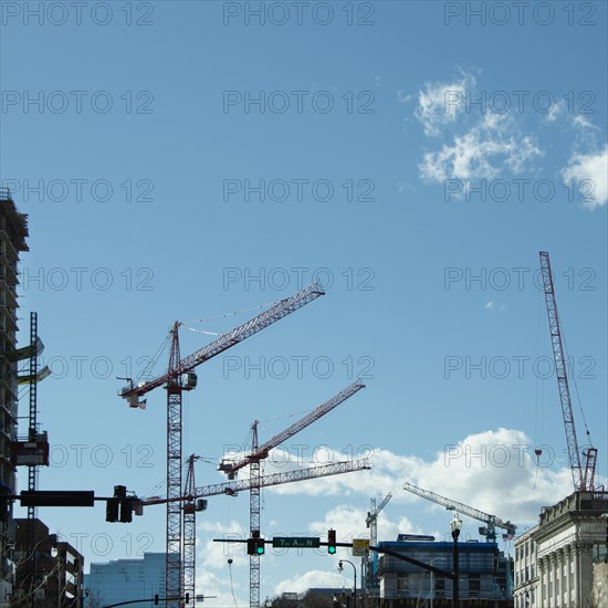 Construction cranes against blue sky