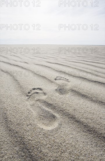 Footprints on rippled sand on beach