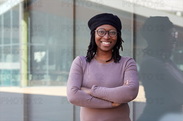 Portrait of smiling woman wearing eyeglasses and beret in city