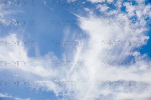 White cirrus clouds against blue sky