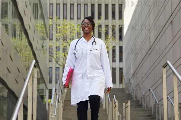 Portrait of smiling female doctor on steps in city