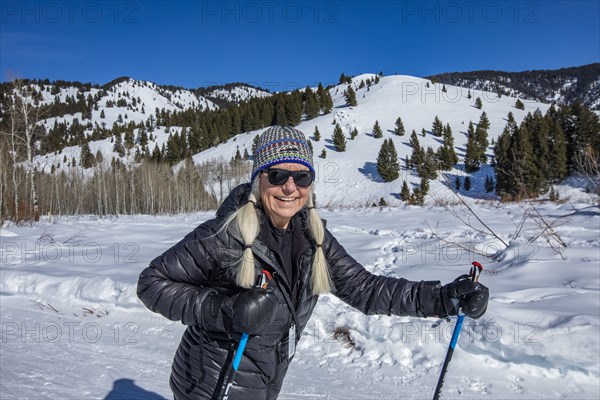 Senior female hiker hiking in mountains in winter