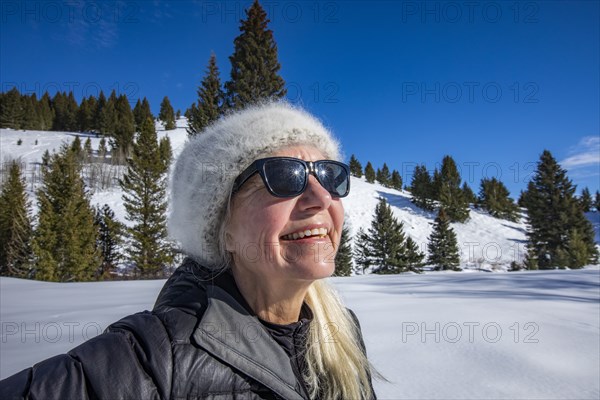 Smiling senior woman relaxing in mountains