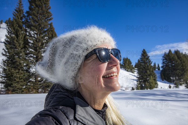 Smiling senior woman relaxing in mountains