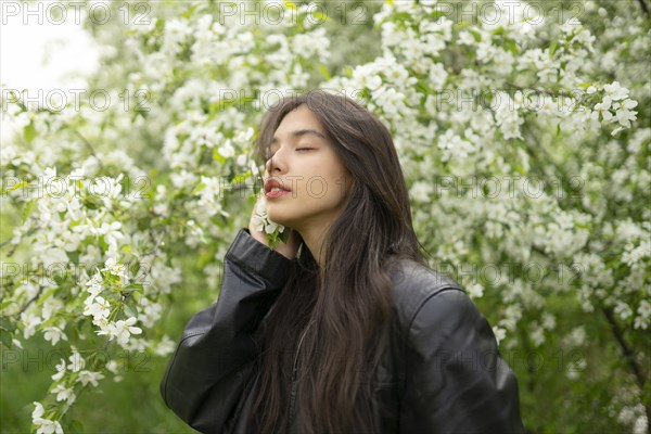 Portrait of teenage girl with blooming apple tree