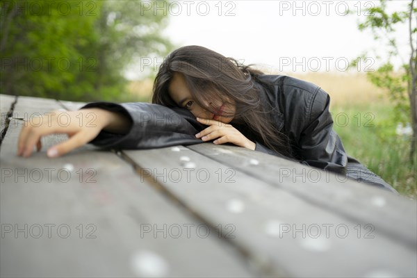 Portrait of teenage girl leaning on picnic table