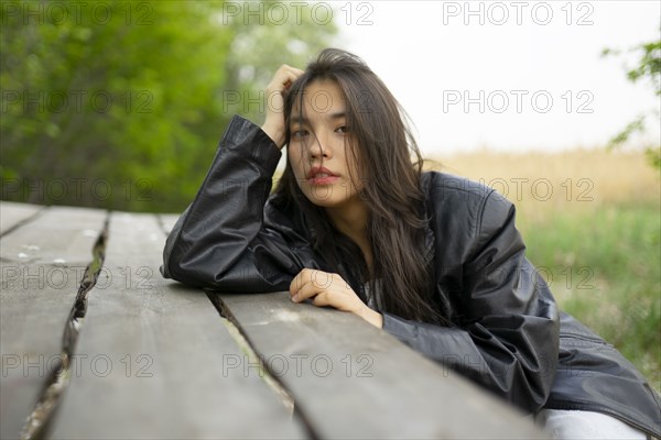 Portrait of teenage girl leaning on picnic table