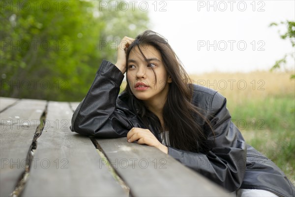 Portrait of teenage girl leaning on picnic table